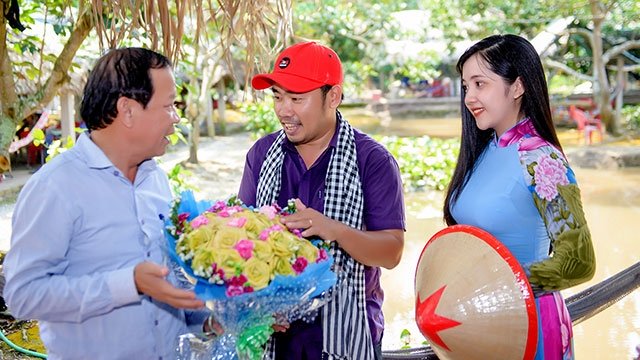 Anh Phong tặng hoa thắt bằng lá dừa cho đại diện khách du lịch.
